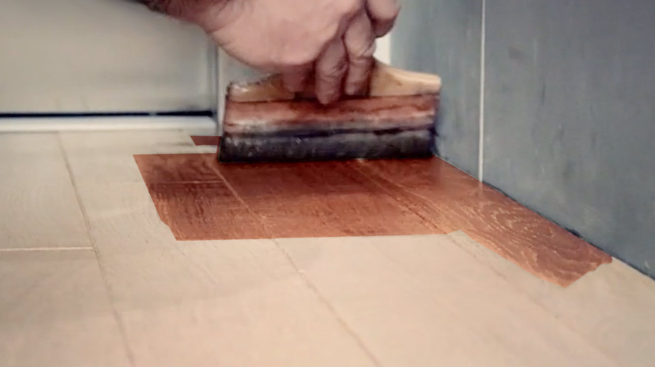 Technicien qui lasure du parquet en bois