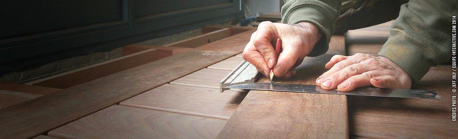 Ouvrier qui trace des repères sur des morceaux de parquet en bois 